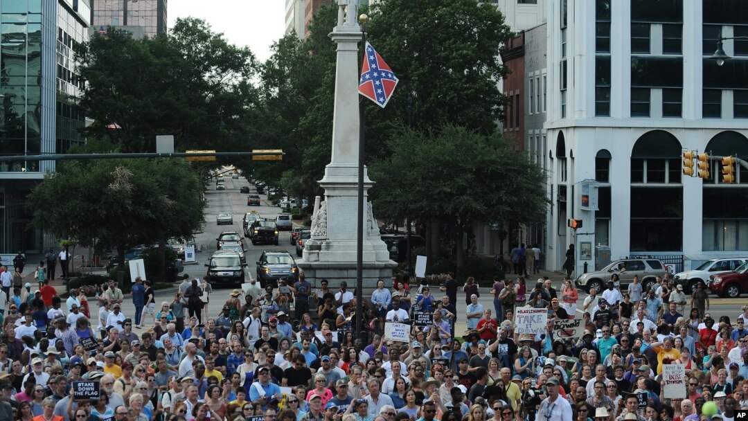 Protesters stand near a flying Confederate flag during a rally in support of its removal from the South Carolina Statehouse grounds in Columbia, June 20, 2015.