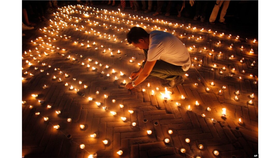 Nepalese people light candles in memory of those who died in last year's devastating earthquake in Basantapur Durbar Square in Kathmandu, Nepal, April 24, 2016.