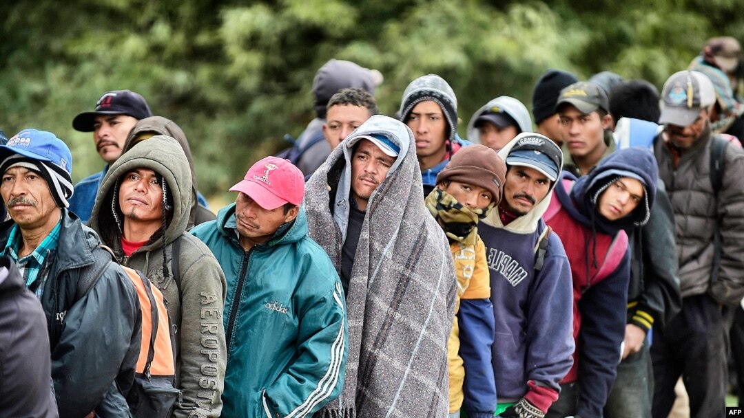 FILE - Migrants wait to receive food donated by the Community Center for Migrant Assistance in the municipality of Caborca in Sonora state, Mexico, Jan. 13, 2017.