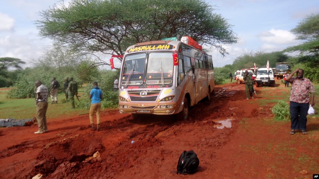 Kenyan security forces and others gather around the scene on an attack on a bus about 50 kilometers (31 miles) outside the town of Mandera, near the Somali border in northeastern Kenya, Nov. 22, 2014.