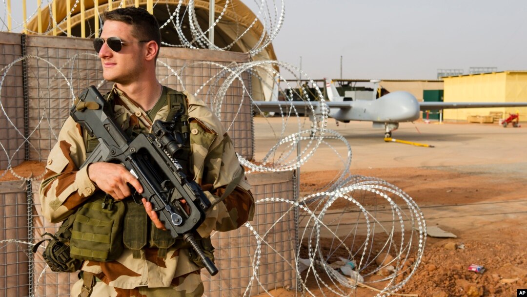 FILE - A French air force soldier on guard near a Hartford drone, at the Niamey military base, in Niger.