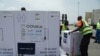 FILE - Workers offload boxes of COVID-19 vaccines distrubuted to lower-income countries under the COVAX initiative, in Abidjan, Ivory Coast, Feb. 26, 2021. 