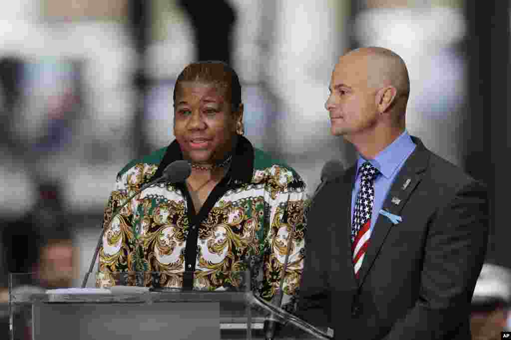 La-Shawn Clark, left, and Mark Cannizzaro read names of victims of the Sept. 11 attacks, Sept. 11, 2018, in New York. Clark lost her husband, Benjamin Clark, and Cannizzaro lost his cousin, Brian Cannizzaro.