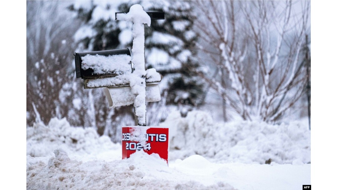 Snow covers a placard for U.S. Republican presidential candidate Florida Governor Ron DeSantis in Davenport, Iowa, on Jan. 11, 2024, as record-breaking cold continues to complicate the Iowa caucuses with snowy weather canceling many events.