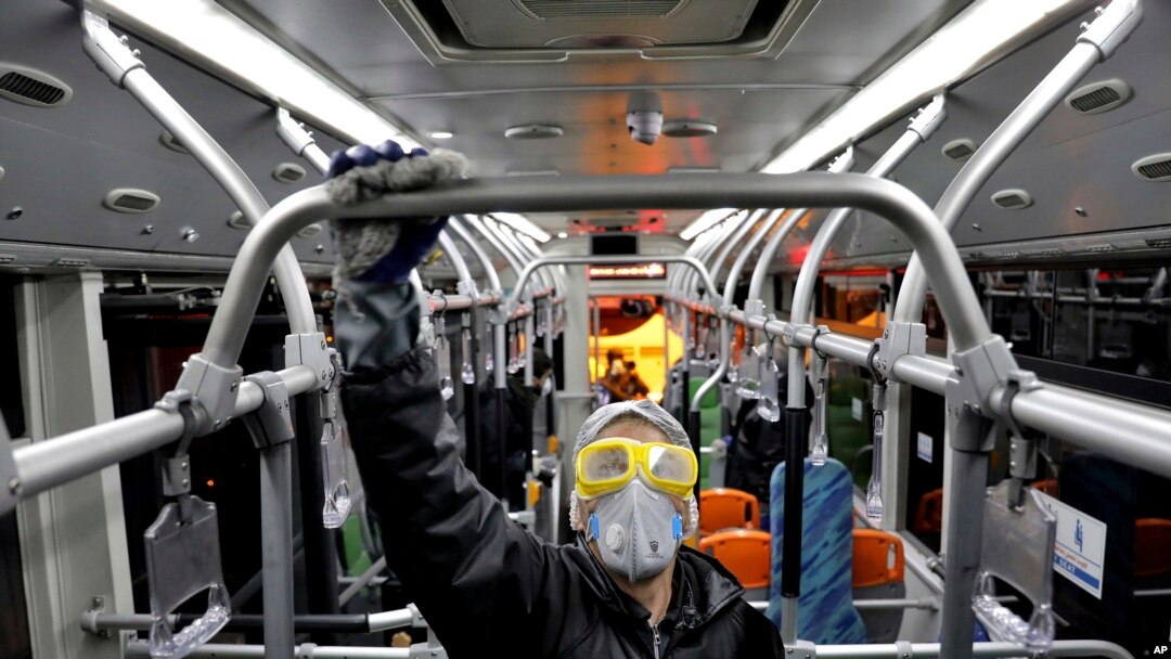 A worker disinfects a public bus against coronavirus in Tehran, Iran, in early morning of Feb. 26, 2020.