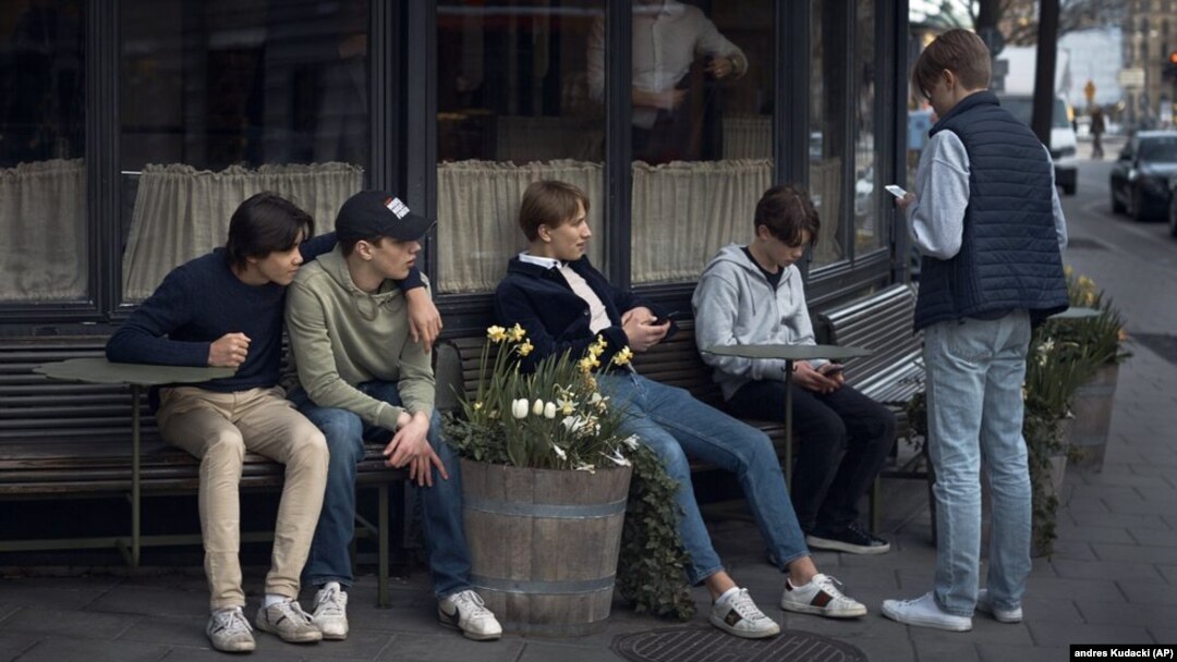 In this Wednesday, April 8, 2020 file photo youths hang out outside a restaurant in Stockholm, Sweden. (AP Photo/Andres Kudacki, File)