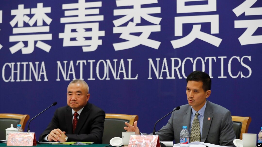 FILE - U.S. Drug Enforcement Administration's representative in Beijing, Lance Ho, right, speaks next to Wei Xiaojun, deputy director-general of the Narcotics Control Bureau of the Ministry of Public Security during a press conference in Beijing, earlier in November 2017. (AP Photo/Andy Wong) 
