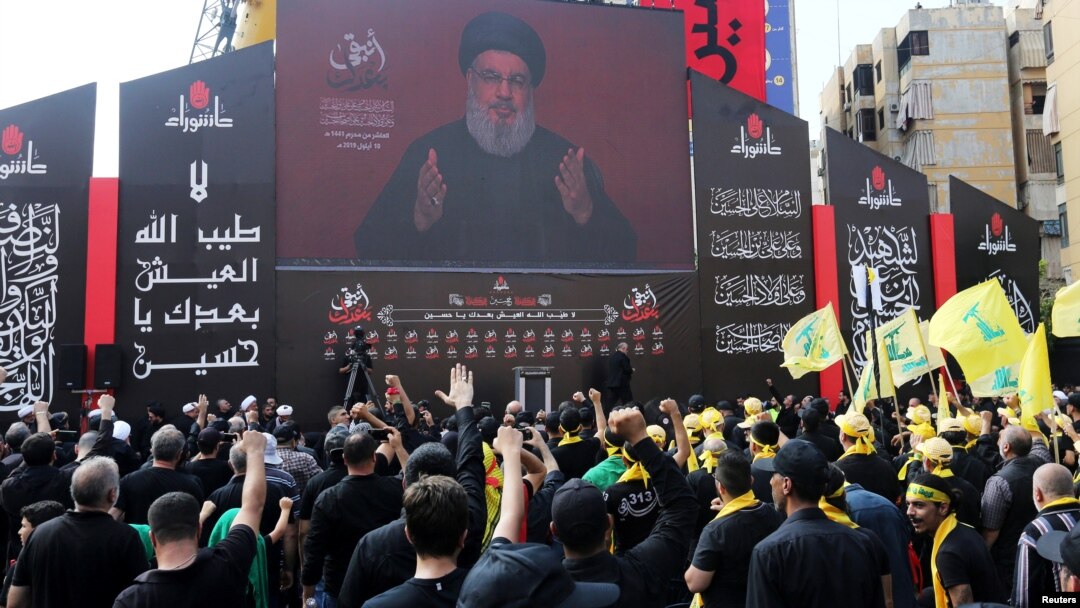 FILE - Lebanon's Hezbollah leader Sayyed Hassan Nasrallah gestures as he addresses his supporters via a screen during the religious procession to mark the Shi'ite Ashura ceremony, in Beirut, Lebanon, Sept. 10, 2019.