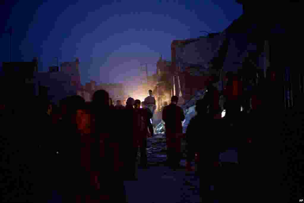 People near a damaged building after it was attacked by a Syrian Army jet in Azaz, Syria, December 16, 2012.