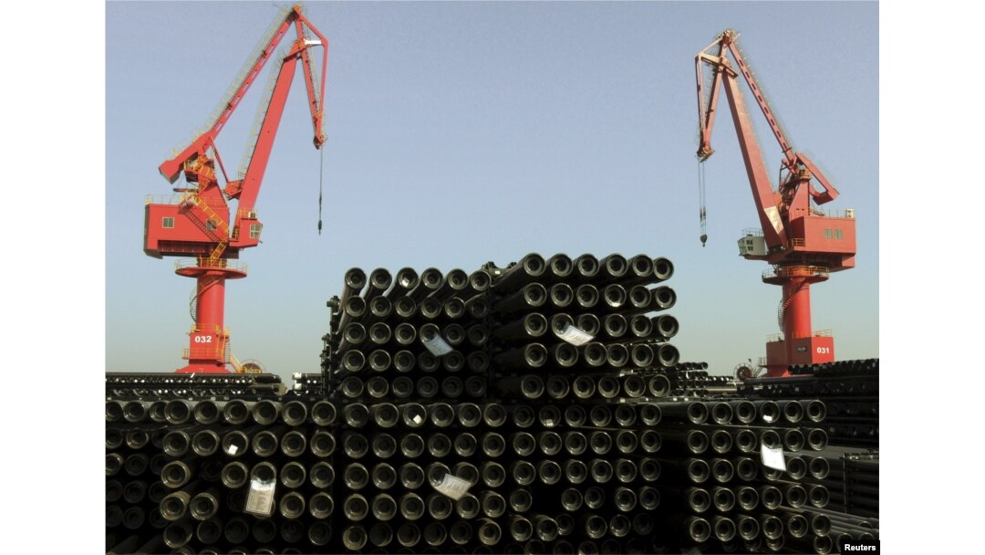 FILE - Cranes are seen above piles of steel pipes to be exported at a port in Lianyungang, Jiangsu province, China, Dec. 1, 2015.
