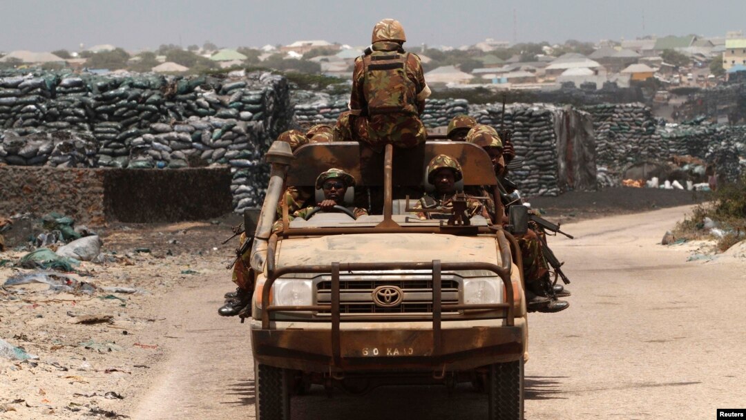 Kenya Defense Force (KDF) soldiers, serving in the African Union Mission in Somalia (AMISOM), patrol past stockpiles of charcoal near the Kismayo sea port town in lower Juba region, Somalia, Feb. 27, 2013.
