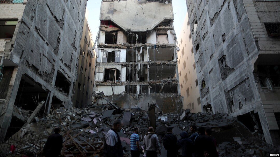Palestinians gather near the remains of a building that was destroyed by an Israeli airstrike, in Gaza City, Nov. 13, 2018.