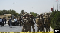  FILE - U.S. soldiers and Afghan security personnel investigate at the site of an attack in Kabul, Afghanistan, Sept. 24, 2017.