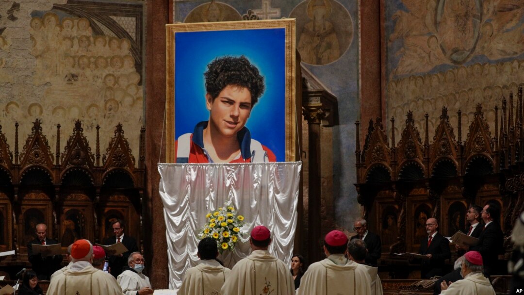 ARCHIVO - Una imagen de Carlo Acutis, de 15 años, un niño italiano que murió en 2006 de leucemia, se revela durante su ceremonia de beatificación celebrada por el cardenal Agostino Vallini en la Basílica de San Francisco, en Asís, Italia, el sábado 1 de octubre de 2019. AP
