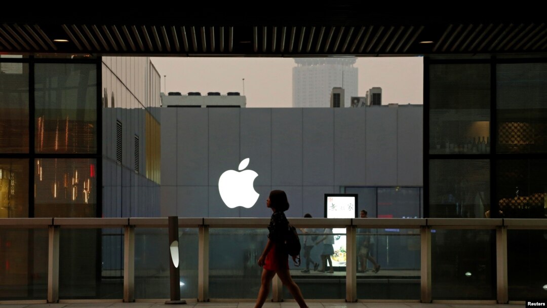 FILE - A woman walks past an Apple store in Beijing, China, July 28, 2016. 