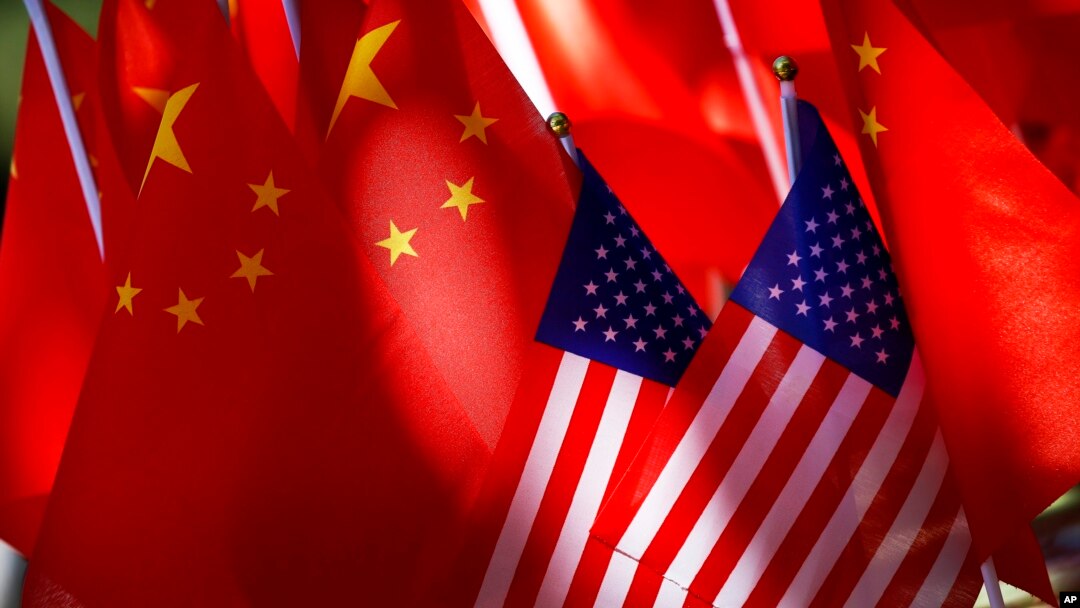 American flags are displayed together with Chinese flags on top of a trishaw in Beijing, Sept. 16, 2018. 