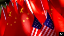 Banderas estadounidenses se muestran junto con banderas chinas en la parte superior de un bicitaxi en Beijing, el 16 de septiembre de 2018.