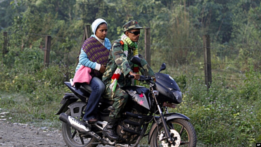 A former Maoist rebel rides a motorbike and arrives with his family for an integration program at Shaktikhor Cantonment in Chitwan, about 220 kilometers (140 miles) southwest of Katmandu, Nepal, November 19, 2011.