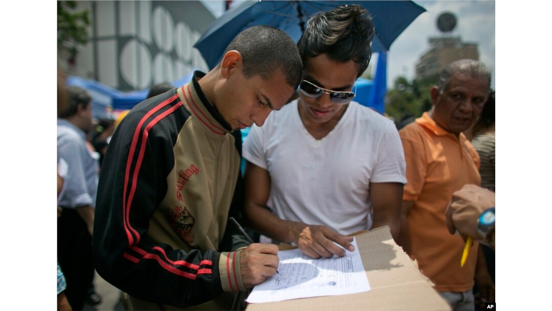 A man signs a petition to initiate a recall referendum against Venezuela's President Nicolas Maduro in Caracas, April 27, 2016.
