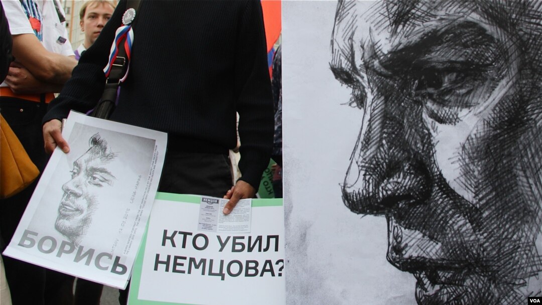 Anti-government protesters hold posters asking who killed opposition leader Boris Nemtsov as they march during an opposition rally in Moscow, Russia, on Sunday, Sept. 20, 2015. (photo by M. Eckels)
