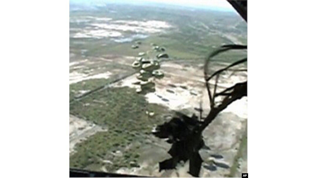 This image taken from video shows relief supplies parachuting from a US Air Force cargo plane flying over Haiti, 19 January 2010 Author: US Air Force