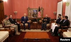 FILE - Afghanistan's President Ashraf Ghani, center right, and U.S. special envoy for peace in Afghanistan, Zalmay Khalilzad,center left, meet in Kabul, Nov.10, 2018.