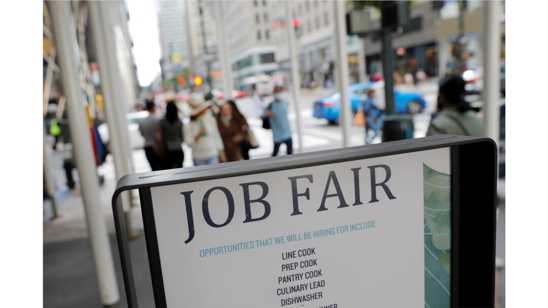 FILE - Signage for a job fair is seen on 5th Avenue in Manhattan, New York City, Sept. 3, 2021.