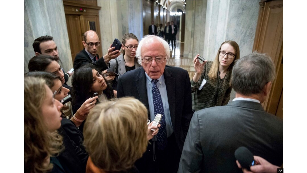 Sen. Bernie Sanders, I-Vt., center, speaks to reporters on Capitol Hill in Washington.