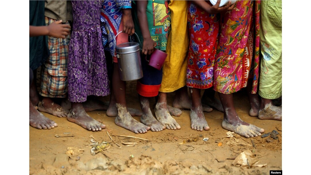 Bare feet of Rohingya refugee children are pictured as they stand in a queue while waiting to receive food outside the distribution center in Palongkhali makeshift refugee camp in Cox's Bazar, Bangladesh, Nov. 7, 2017.