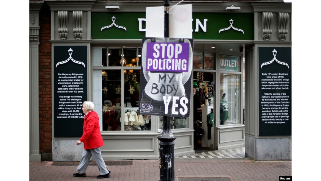 A woman walks past a pro-choice poster in the city centre of Dublin, Ireland, May 22, 2018.