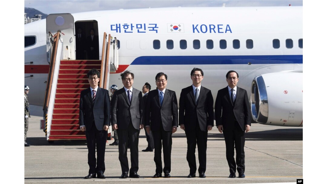 South Korea's national security director Chung Eui-yong, center, National Intelligence Service Chief Suh Hoon, second left, and other delegators pose before boarding an aircraft as they leave for Pyongyang at a military airport