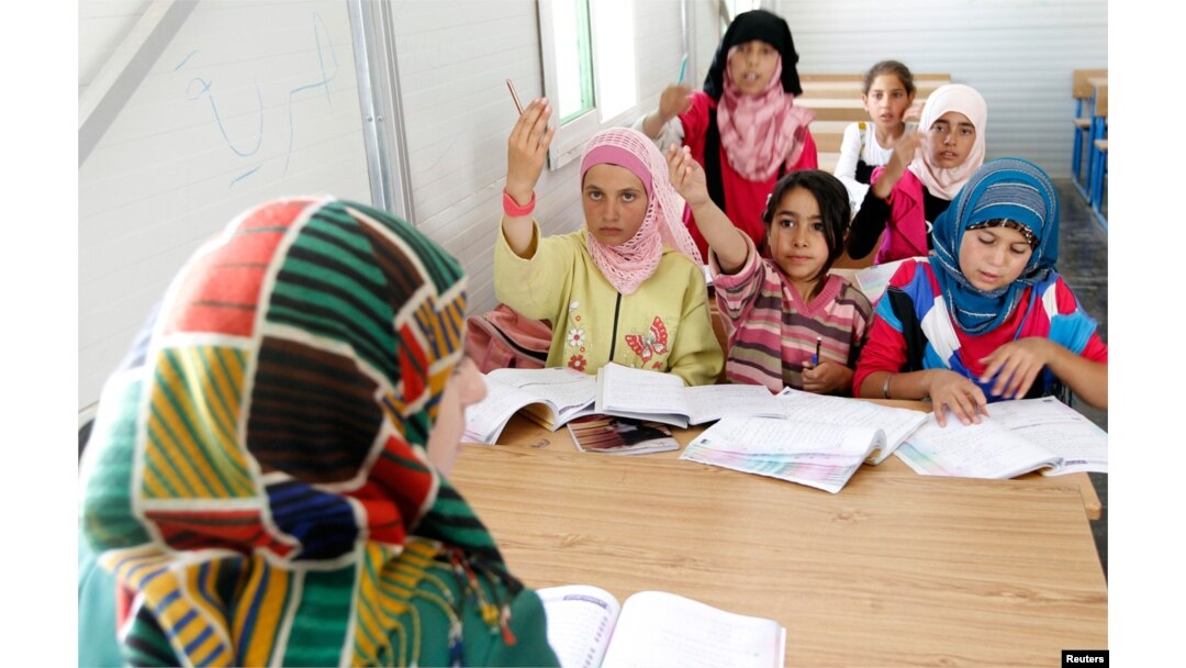 FILE - Syrian refugee children attend a class during the opening of a new school at the Al Zaatri refugee camp in the Jordanian city of Mafraq, near the border with Syria, June 4, 2013.