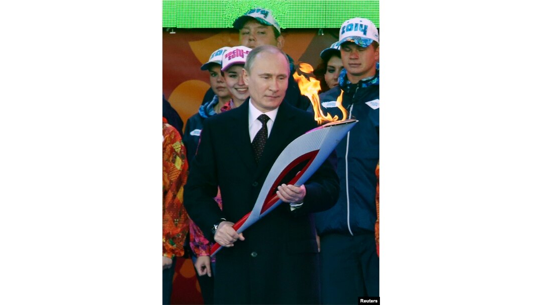 Russian President Vladimir Putin holds a lighted Olympic torch during a ceremony to mark the start of the Sochi 2014 Winter Olympic torch relay in Moscow, Oct. 6, 2013.