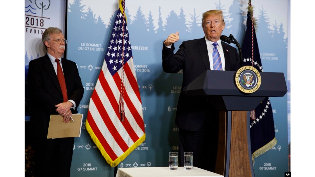 National Security Adviser John Bolton looks on as President Donald Trump speaks during a news conference at the G-7 summit, June 9, 2018, in La Malbaie, Quebec, Canada.