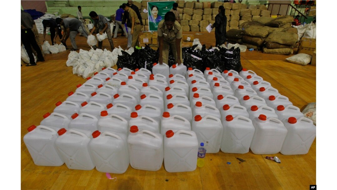 A policewoman sorts drinking water to be distributed to flood victims at the Jawarhalal Nehru Indoor stadium in Chennai, India, Dec. 6, 2015.