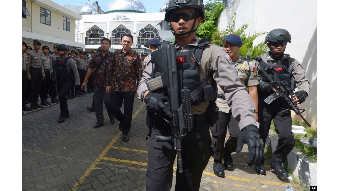Jakarta Governor Basuki Tjahaja Purnama, popularly known as "Ahok," center, is escorted by anti-terror policemen as he leaves North Jakarta District Court in Jakarta, Indonesia Tuesday, Dec. 20, 2016.