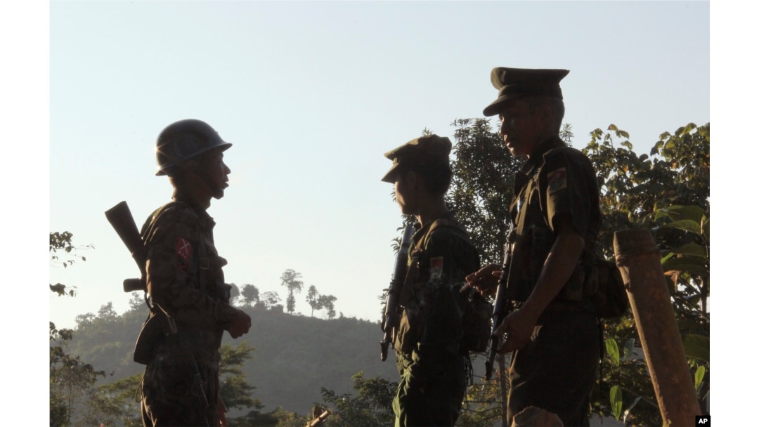 FILE - Three Kachin Independence Army (KIA) soldiers patrol along the bunker at the front line of on a mountain near Laiza, the headquarters of KIA in Kachin State, Myanmar. Nov. 30, 2016.