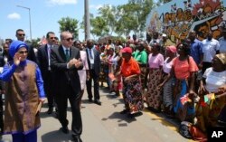 FILE - Turkey's President Recep Tayyip Erdogan and his wife, Emine Erdogan, greet local people during a ceremony in Maputo, Mozambique, Jan. 24, 2017.