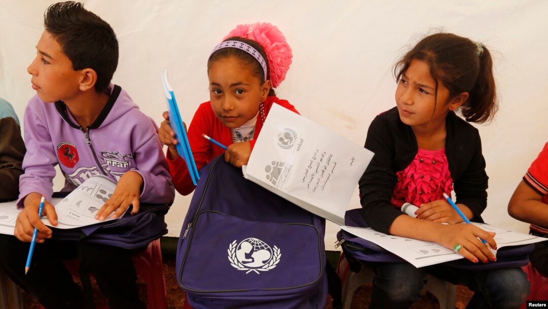 FILE - Syrian refugee children attend an English lesson inside a makeshift school tent during a visit by UNICEF Executive Director Anthony Lake.