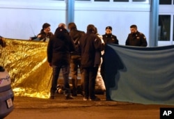 Italian police cordon off an area around a body after a shootout between police and a man in Milan's Sesto San Giovanni neighborhood, Dec. 23, 2016.