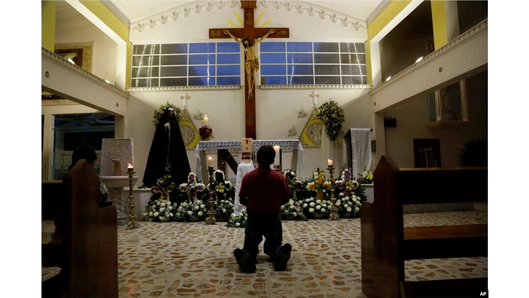 A person prays in Our Lady of Fatima Church in Poza Rica, Veracruz state, Mexico, Sept. 20, 2016. Two of the church's priests were found dead Monday, and were last seen Sunday. Their bullet-ridden bodies were found on a roadside.