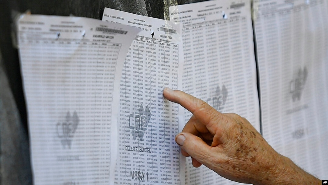 Un hombre busca su número de identificación en una lista de votantes durante un ensayo de votación en la escuela secundaria Andrés Bello en Caracas, el 10 de octubre de 2021.