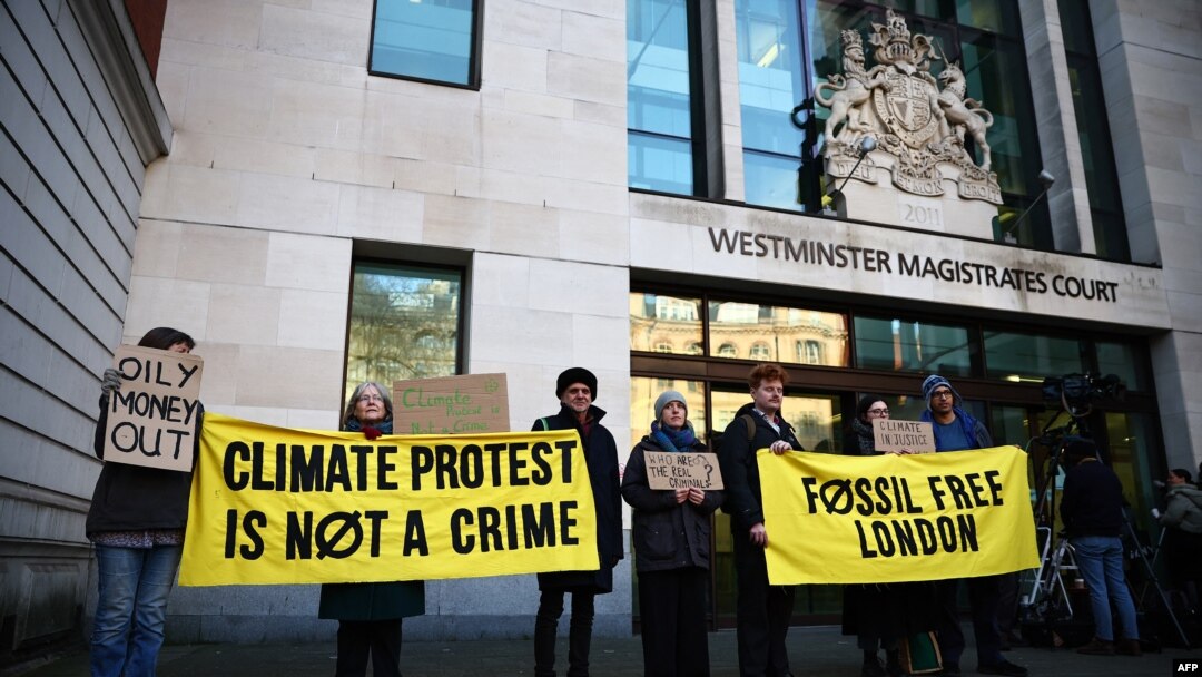 Manifestantes sostienen pancartas antes de la llegada de la activista ambiental sueca Greta Thunberg y otras cuatro personas al Tribunal de Magistrados de Westminster en Londres el 1 de febrero de 2024, para el primer día de juicio.
