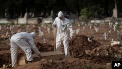 Pogrebnici u zaštitnim odelima sahranjuju sanduk sa telom 57-ogodišnjeg Pauda Hosea de Silve, žrtve koronavirusa u Rio de Ženeiru, Brazil, 5. juna 2020.