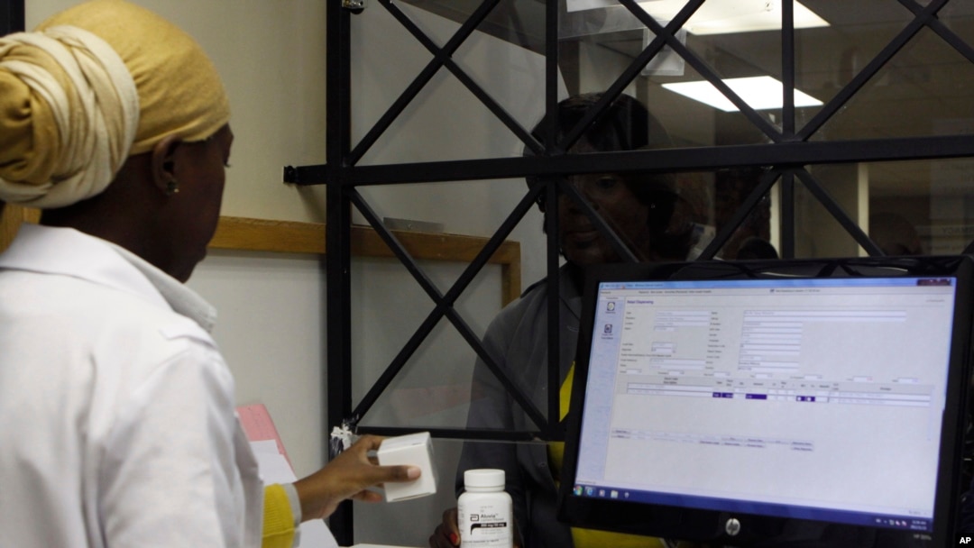 FILE - A woman receives her medication from a pharmacist at the Helen Joseph hospital, in Johannesburg, South Africa, Nov. 15, 2012.