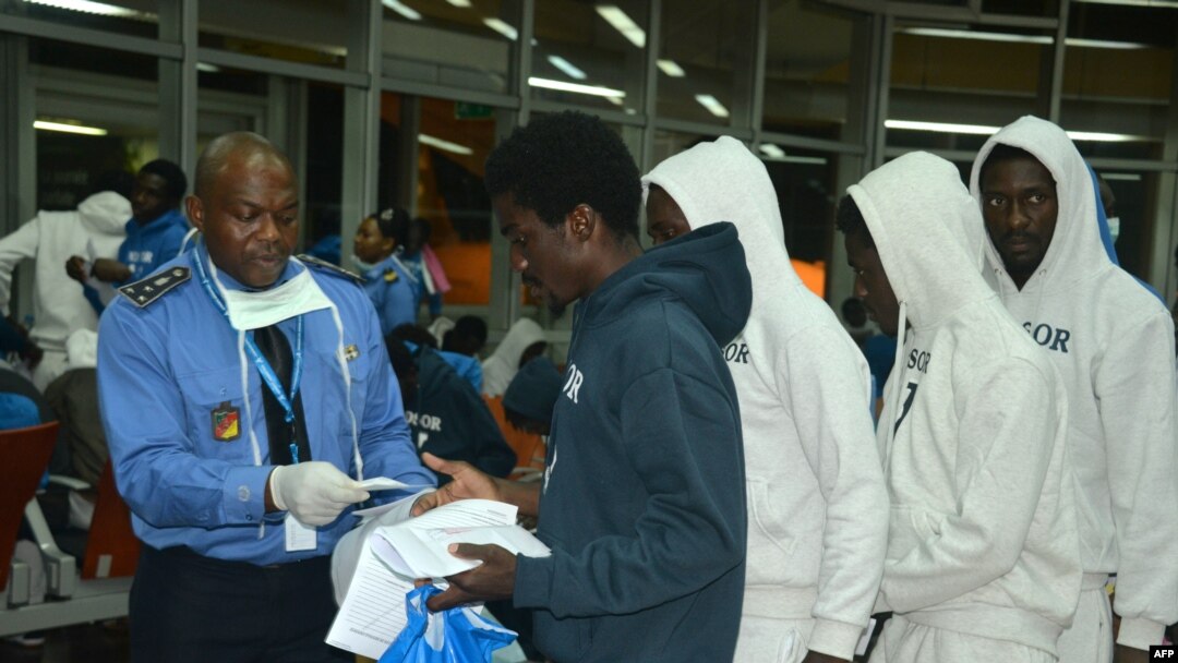 FILE - Cameroonian migrants receive registration forms upon their arrival after spending several months in Libya, at the Yaounde International Airport in Cameroon, Nov.r 22, 2017.
