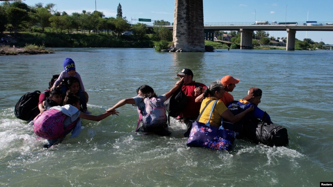 Migrantes cruzan el Río Grande en medio de fuertes corrientes provenientes de México en Eagle Pass, Texas, EEUU, el 29 de septiembre de 2023.
