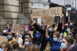 Protesters call for the removal of the statue of 19th century imperialist, politician Cecil Rhodes from the Oriel college in Oxford, England, June 9, 2020.