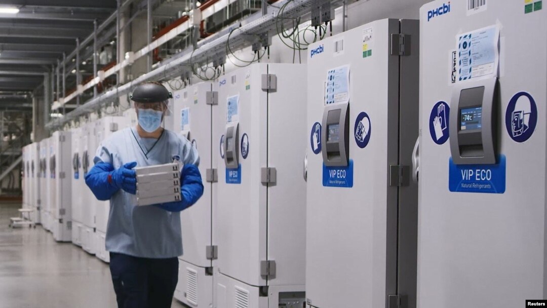 A worker passes a line of freezers holding coronavirus disease (COVID-19) vaccine candidate BNT162b2 at a Pfizer facility in Puurs, Belgium in an undated photograph. (Pfizer/Handout via REUTERS)