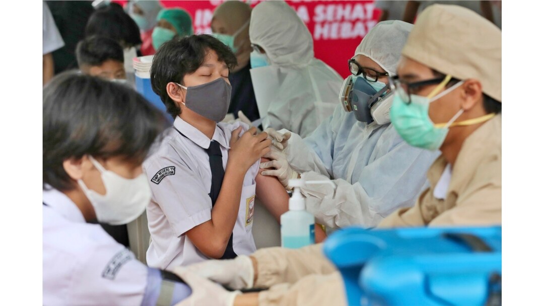 A student reacts as a medical worker administers a shot of the Sinovac COVID-19 vaccine during a vaccination campaign for children ages 12-17 at a school in Tangerang, Indonesia, July 14, 2021.